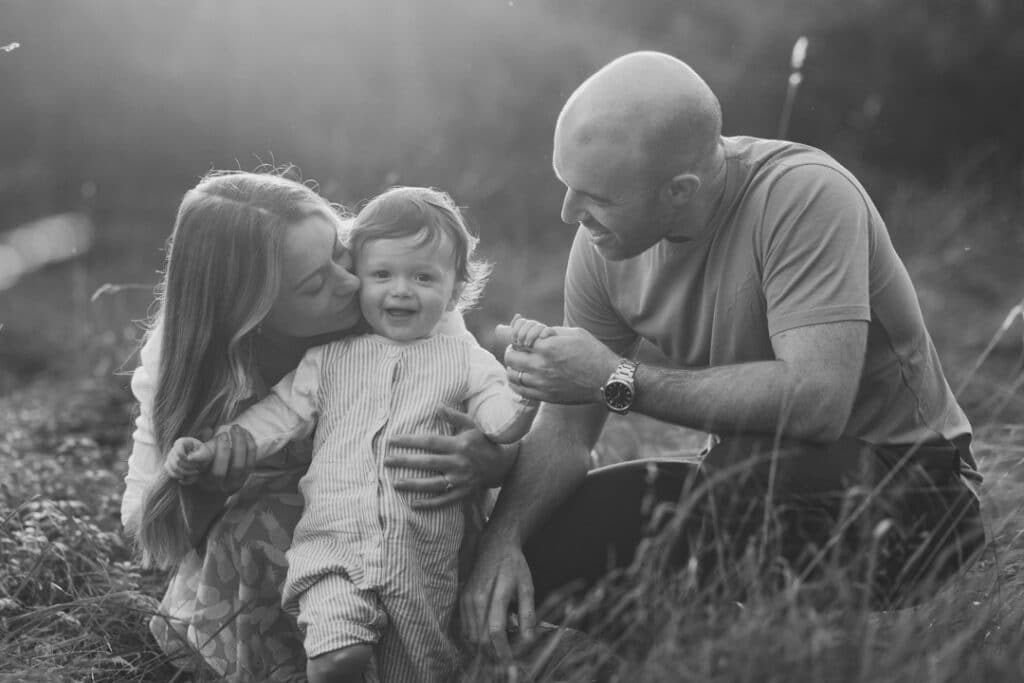 Mum and dad are looking at the boy and he is looking at the camera. natural lifestyle family photo session in Hampshire. Ewa Jones Photography