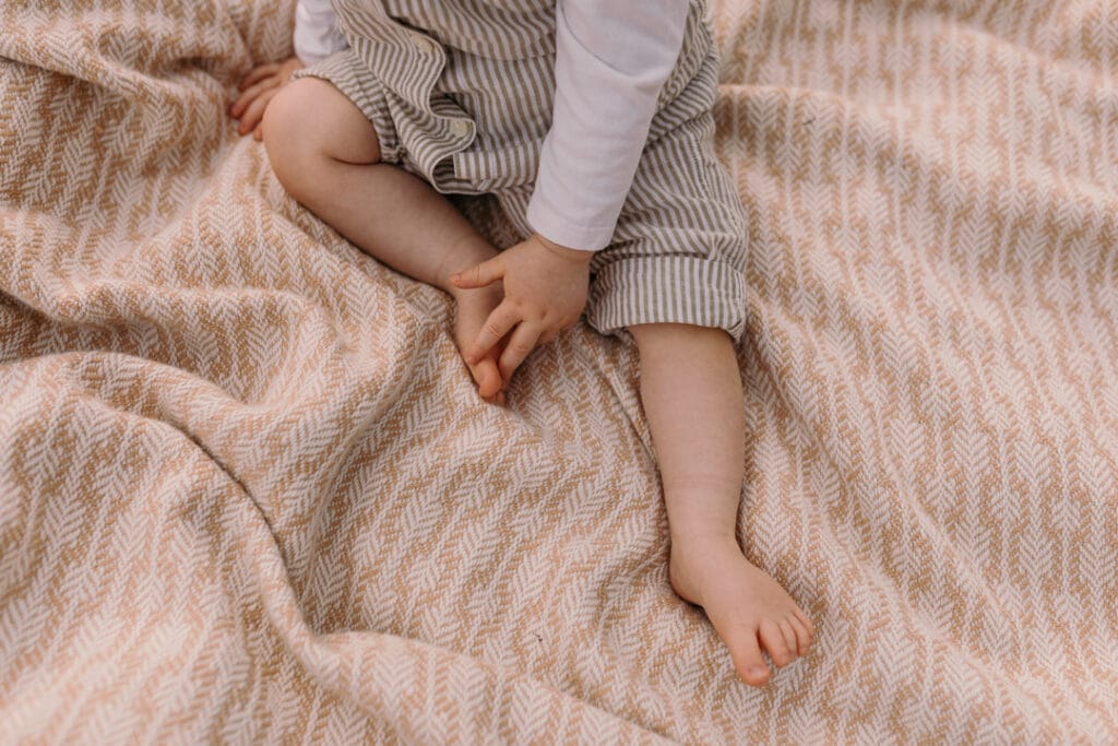 Close up detail of boy feet who is sitting on the blanket. Natural family photographer in Basingstoke, Hampshire. Ewa Jones Photography