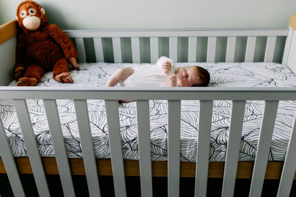 Newborn baby girl is sleeping in her cot. newborn photo shoot in Hampshire. Ewa Jones Photography