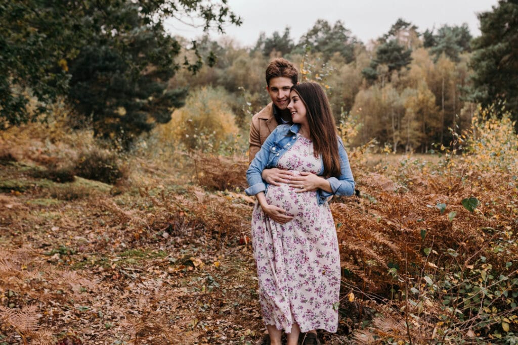 Mum and dad are holding together and touching baby bump. Maternity photo shoot in Basingstoke. Basingstoke photographer. Ewa Jones Photography