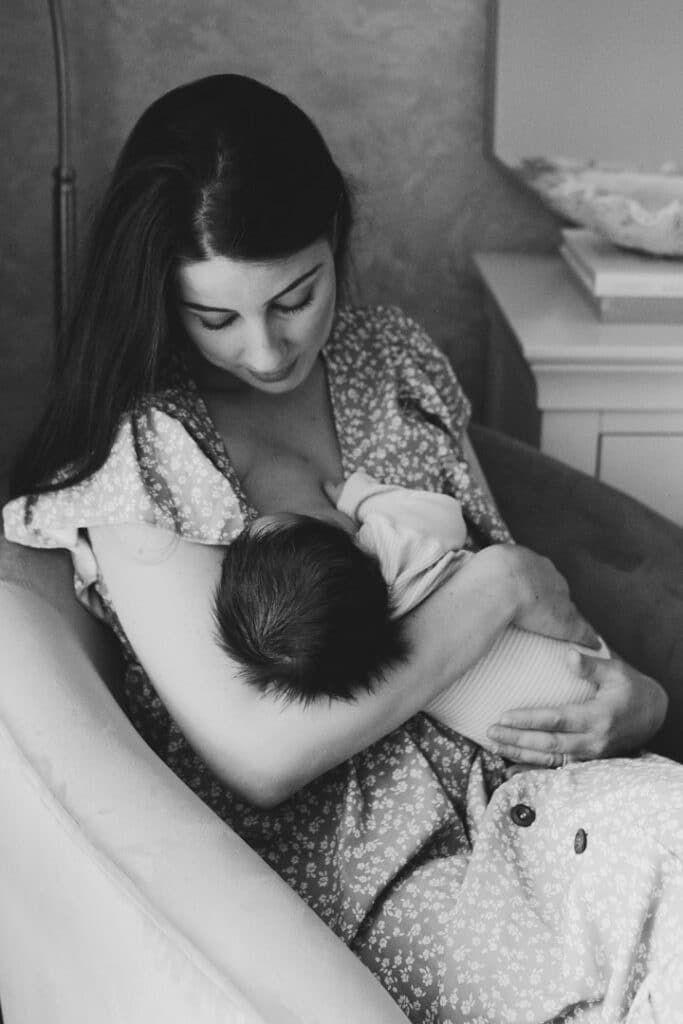Mum is breastfeeding her baby girl. Black and white candid image. Newborn photographer in Basingstoke, Hampshire. My favourite newborn photographs of 2021. Ewa Jones Photography
