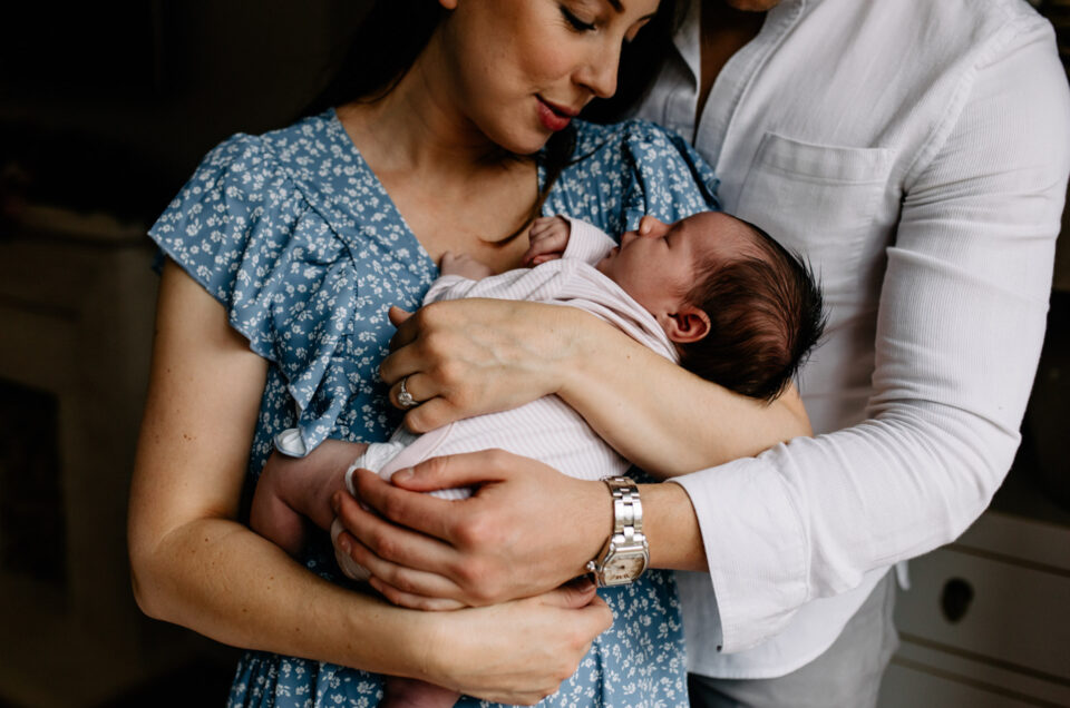 Mum is holding her newborn baby girl in her arms and looking down on her. Newborn photographer in Basingstoke, Hampshire. My favourite newborn photographs of 2021. Ewa Jones Photgraphy