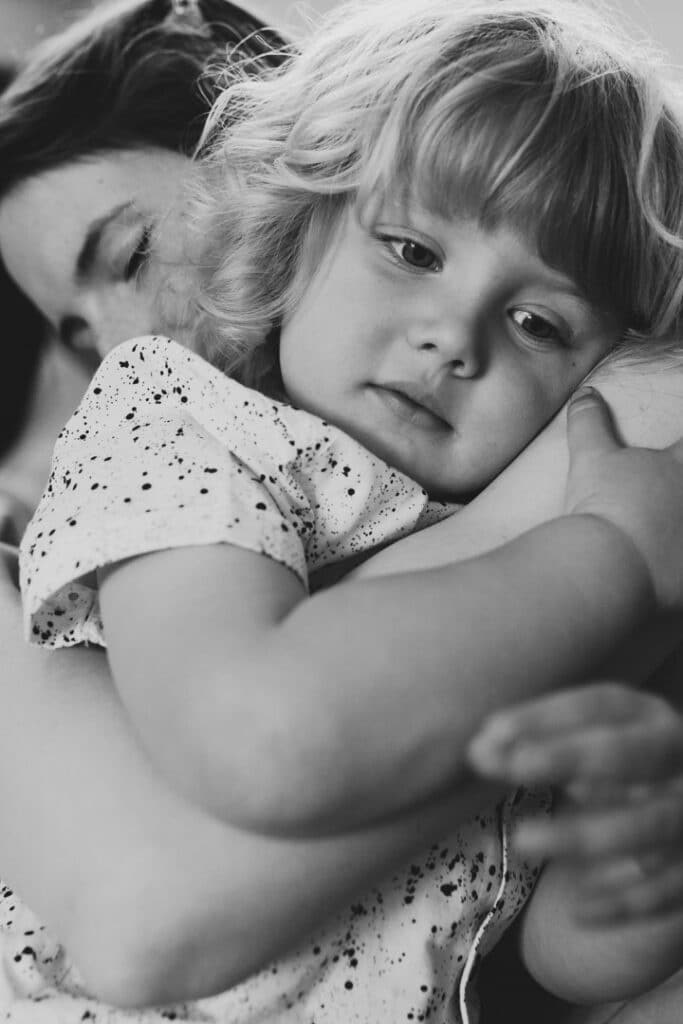 little boy is cuddling up to his mum. Mum has her eyes closed. Lovely candid natural photograph. Lifestyle photograph in Basingstoke, Hampshire. Ewa Jones Photography