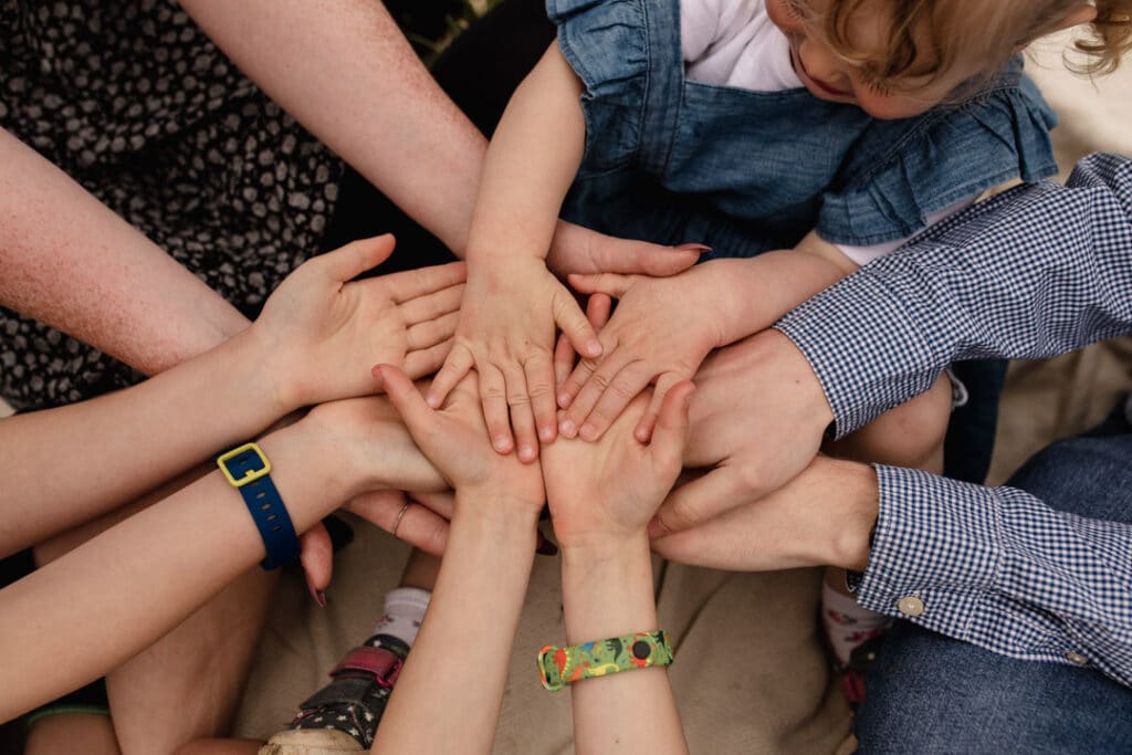 Family is holding hands together. Lovely siblings family image. Family photographer in Hampshire. Ewa Jones Photography