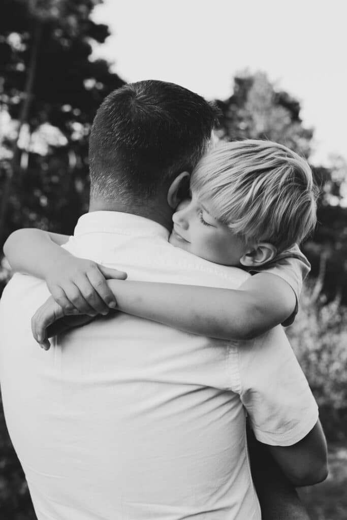 dad is cuddling his son and his son has closed eyes. Family posing ideas for family photo sessions. Basingstoke family photographer. Ewa Jones Photography