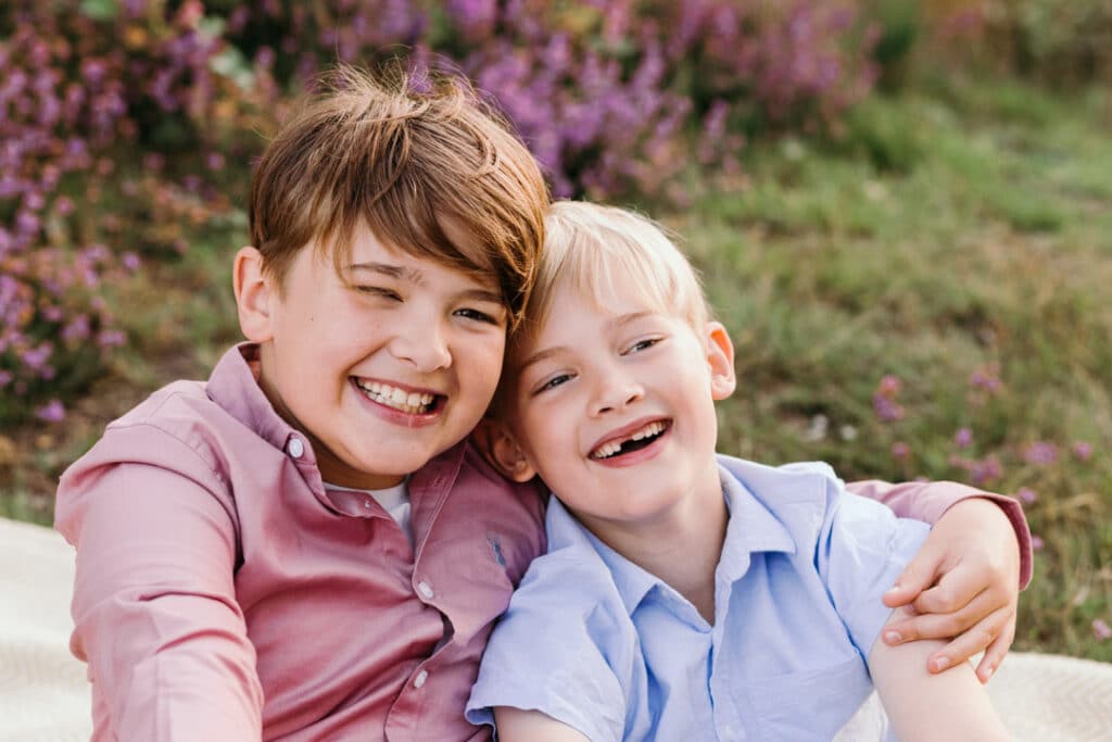 two brothers are cuddling to each other and smiling. natural family photo session in Hook, Hampshire. Ewa Jones Photography