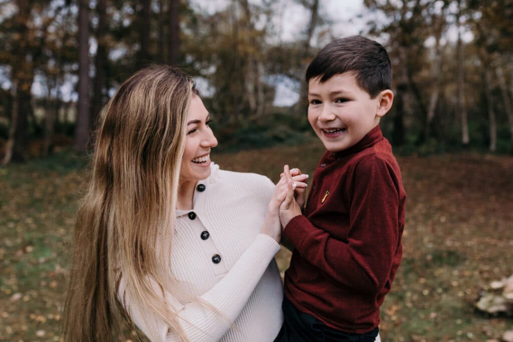 Mum is holding her boy on her arms and they are smiling. unposed mum and son family photo session in Hampshire. Hampshire photographer. Ewa Jones Photographer