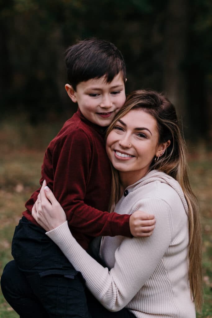 Mum and her little boy are cuddling to each other. Lovely mum and son photograph in Autumn. Family photo shoot in Hampshire. My favourite family photographs of 2021. Ewa Jones Photography