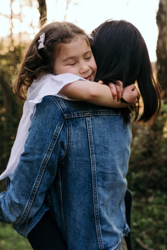 Little girl is cuddling to her mum and has her eyes closed. Natural lifestyle family photo session in Hampshire. Hampshire photographer. Ewa Jones Photography