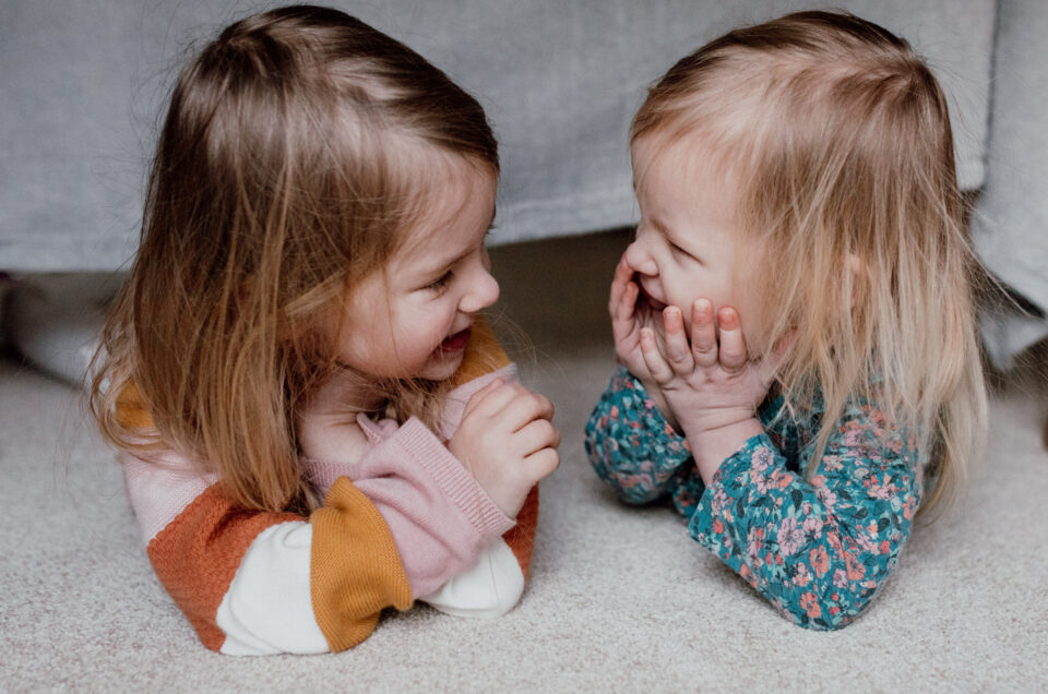 two girls are laying on their tummies and looking and smiling to each other. Five baby and kids activities in Basingstoke you must try. Basingstoke photographer. Ewa Jones Photography