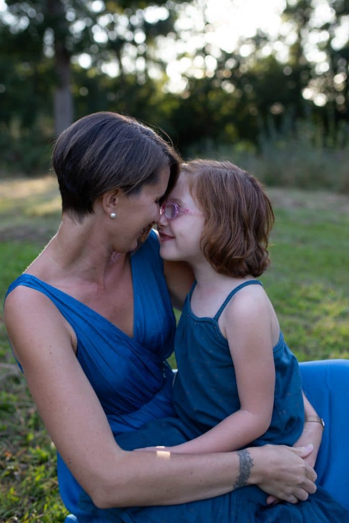 Mum is cuddling up to her daughter and they are looking at each other. Family photo shoot in Hampshire. Hampshire photographer. Ewa Jones Photography