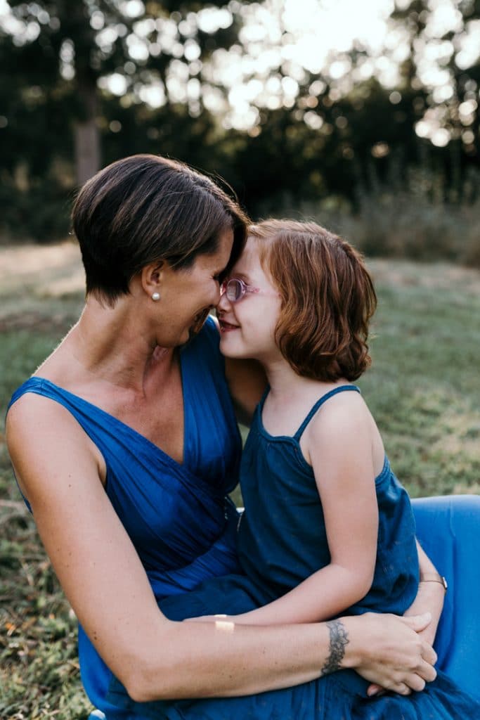 Mum is cuddling up to her daughter and they are looking at each other. Family photo shoot in Hampshire. Hampshire photographer. Ewa Jones Photography