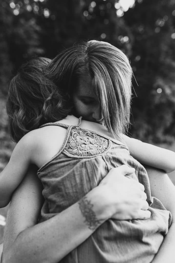 Black and white image of mum cuddling to her daughter. Family photo shoot in Hampshire. Basingstoke photographer. Ewa Jones Photography