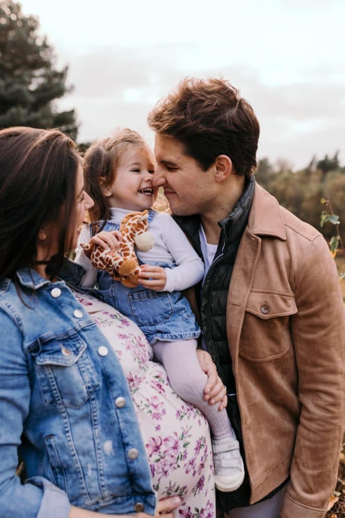 Mum and dad are looking at their little girl and smiling. Maternity photographer in Basingstoke, Hampshire. Ewa Jones Photography