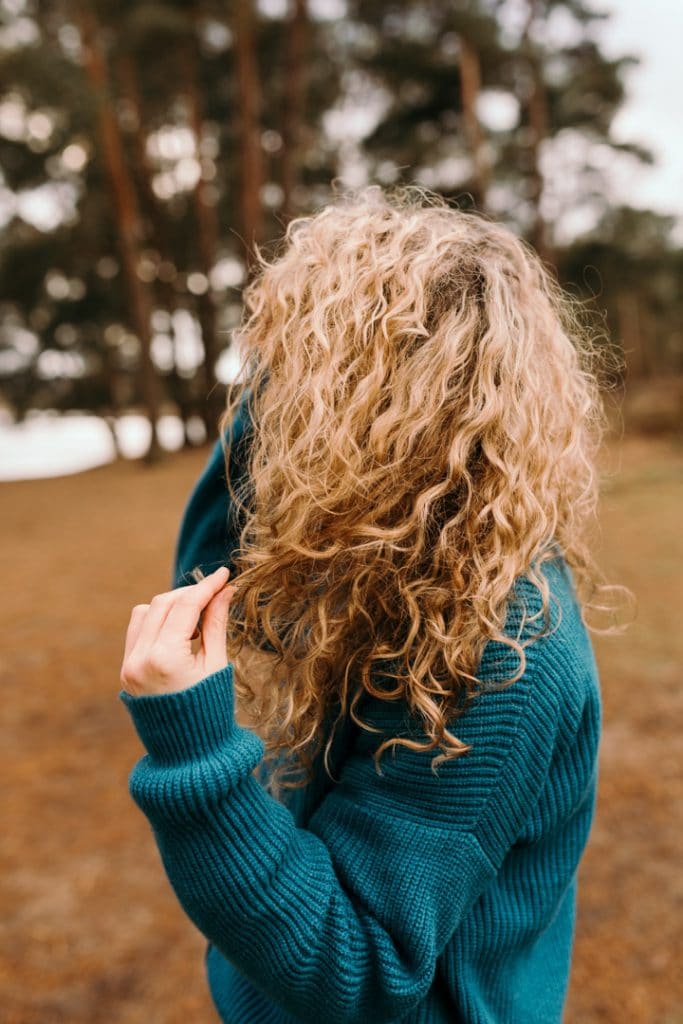 Detail shot of a female curly hair. Female is wearing a blue jumper and looking away. female photography in Hampshire. Basingstoke photographer. Ewa Jones Photography