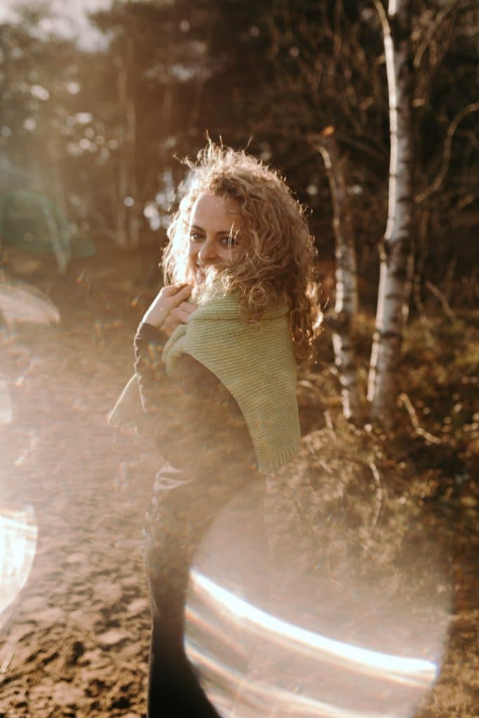 Lovely image of a female looking at the camera. sun is shining and there is a flare of the sun at the bottom of the image. Female photo shoot in Hampshire. Basingstoke photographer. Ewa Jones Photography