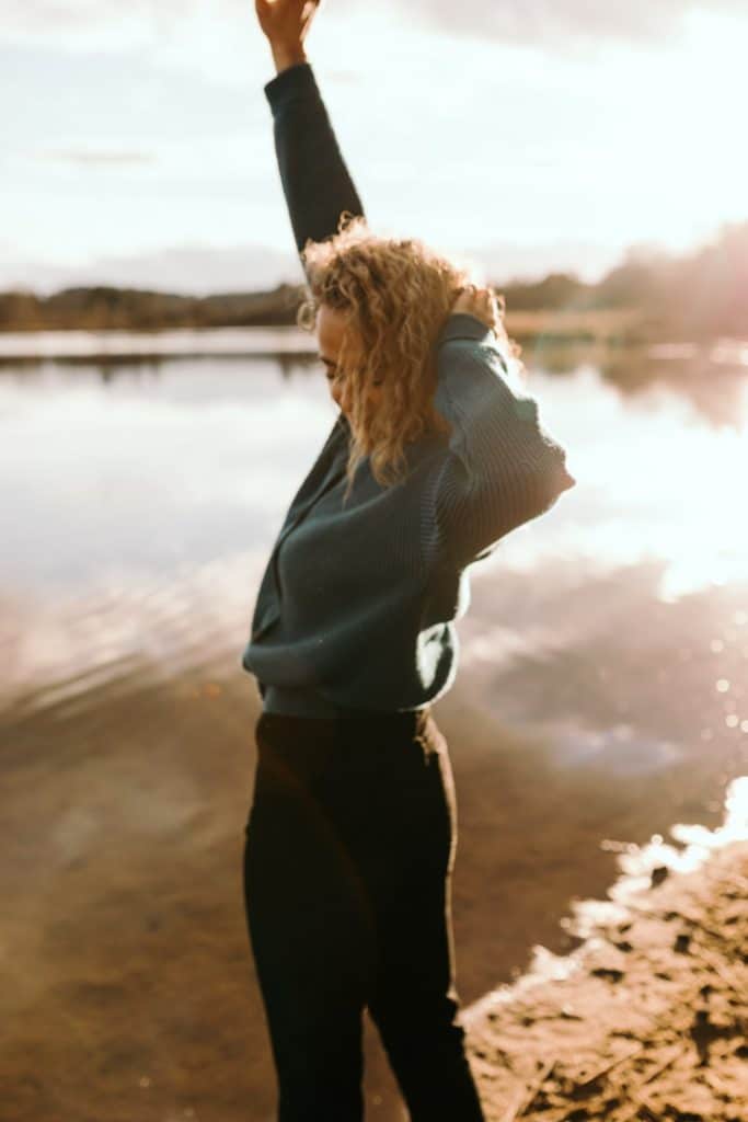 Woman is standing next to the water and looking down. Natural woman photo shoot in Hampshire. Basingstoke photographer. Ewa Jones Photography