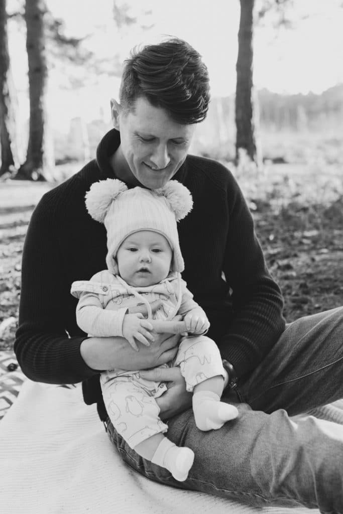 Black and white photograph of dad holding his baby boy. Natural lifestyle photography in Hampshire. Ewa Jones Photography