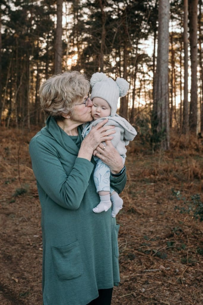 Grandma is kissing her little baby grandson. Family photo session in the nature common. Hampshire photographer. Ewa Jones Photography