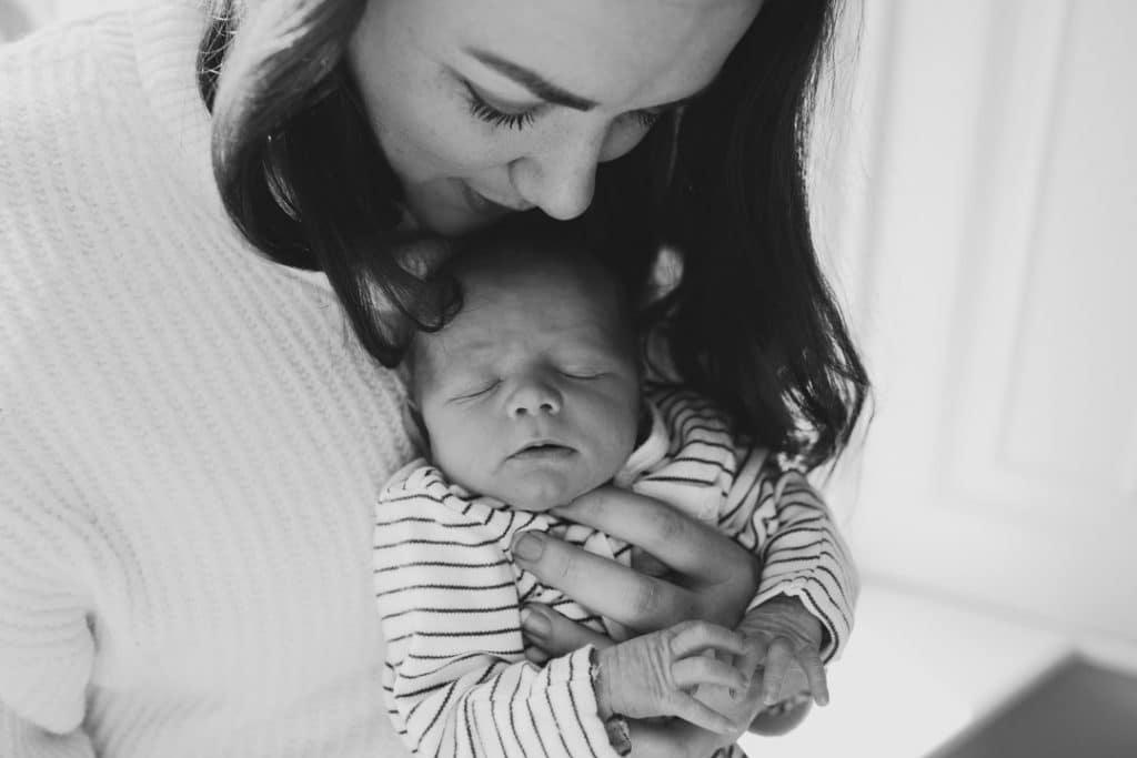 Mum is cuddling her newborn baby. Newborn baby photo session in Hampshire. Ewa Jones Photography