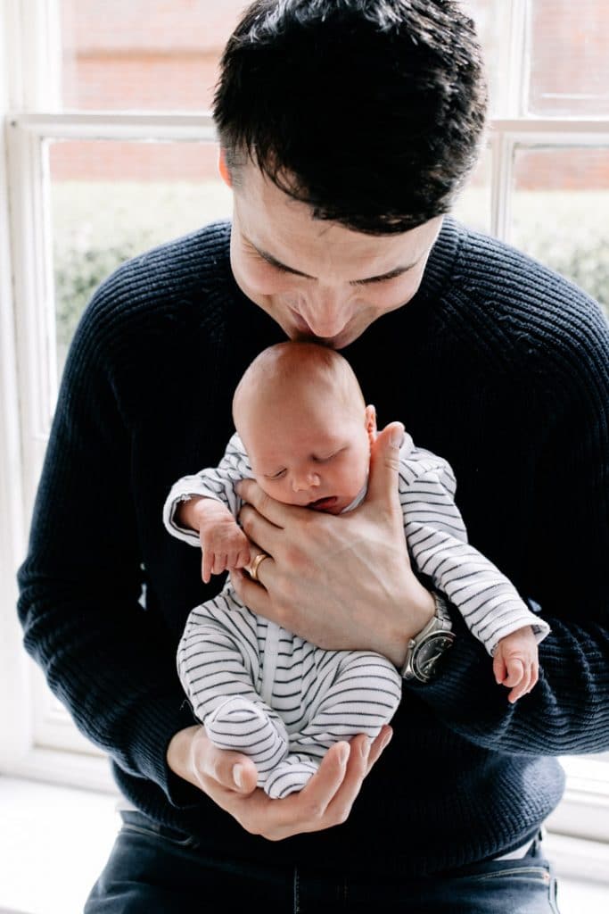 Dad is holding his newborn baby. Newborn photographer in Hampshire. Ewa Jones Photography