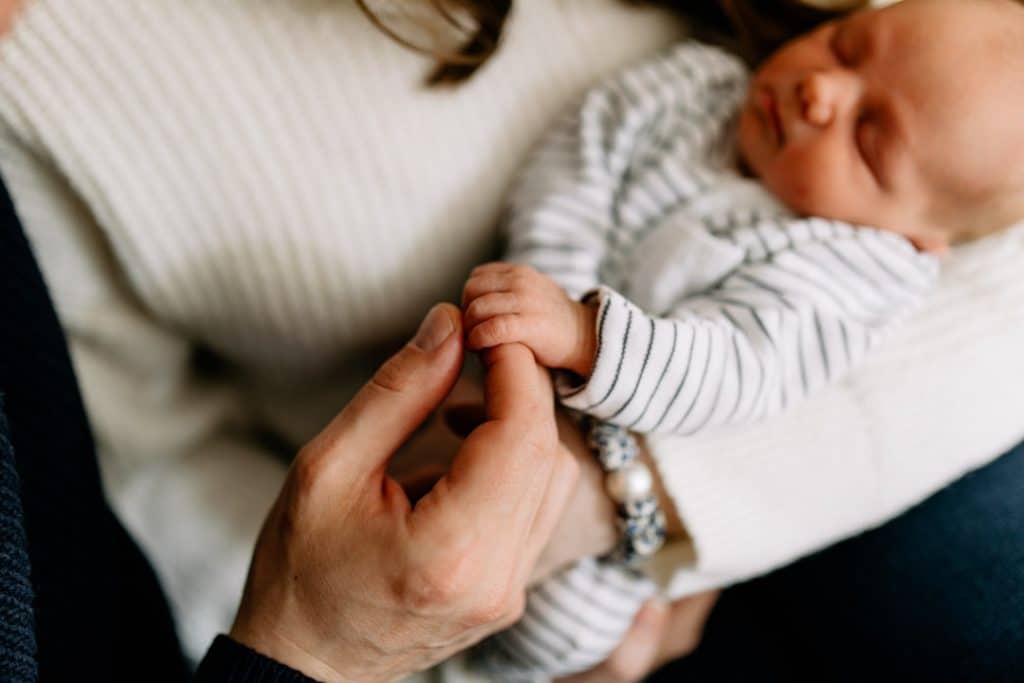 Newborn baby boy is holding his dad finger. detail shot from newborn photo session in Hampshire. Ewa Jones Photography