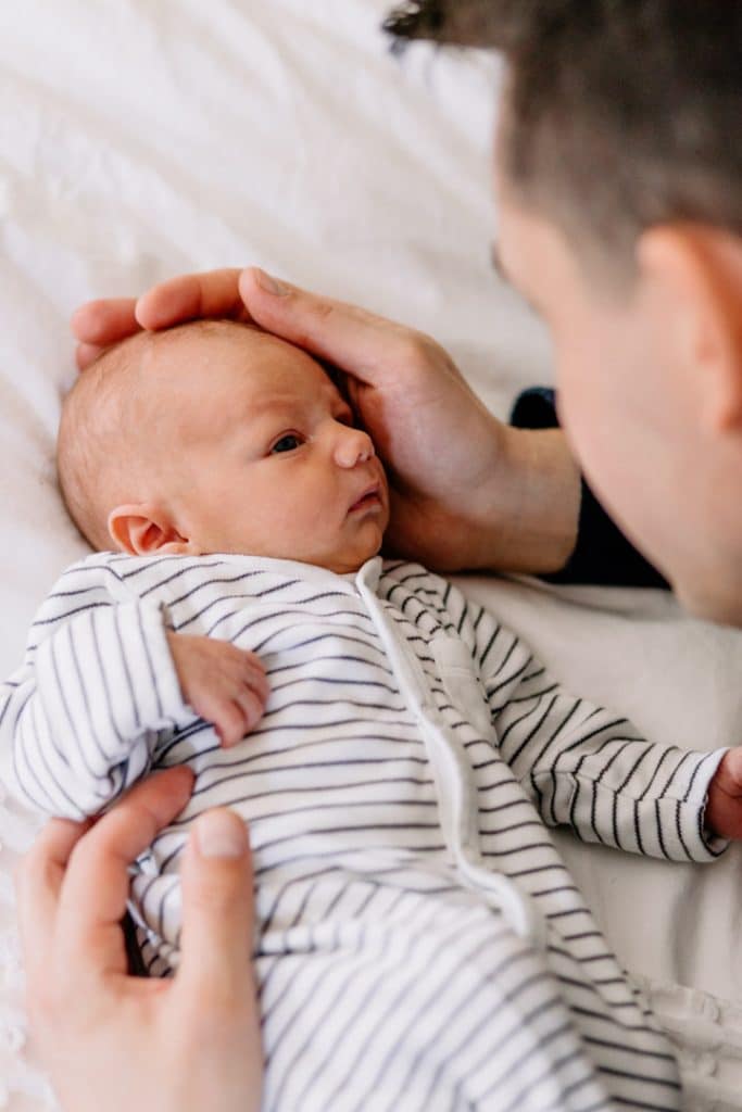 Newborn baby boy is looking at his dad. Newborn photographer in Basingstoke. Ewa Jones Photography