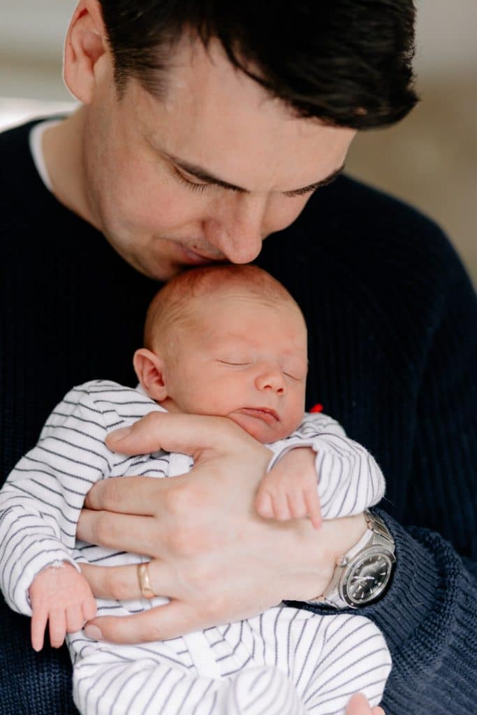 dad is holding his newborn baby boy. Newborn photographer in Hampshire. Ewa Jones Photography