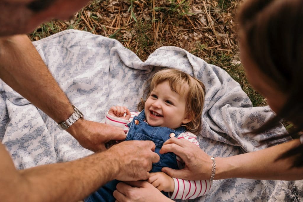 Mum and dad are tickling their girl. Benefits of an outdoor family photoshoot. Hampshire family photographer. Ewa Jones Photography