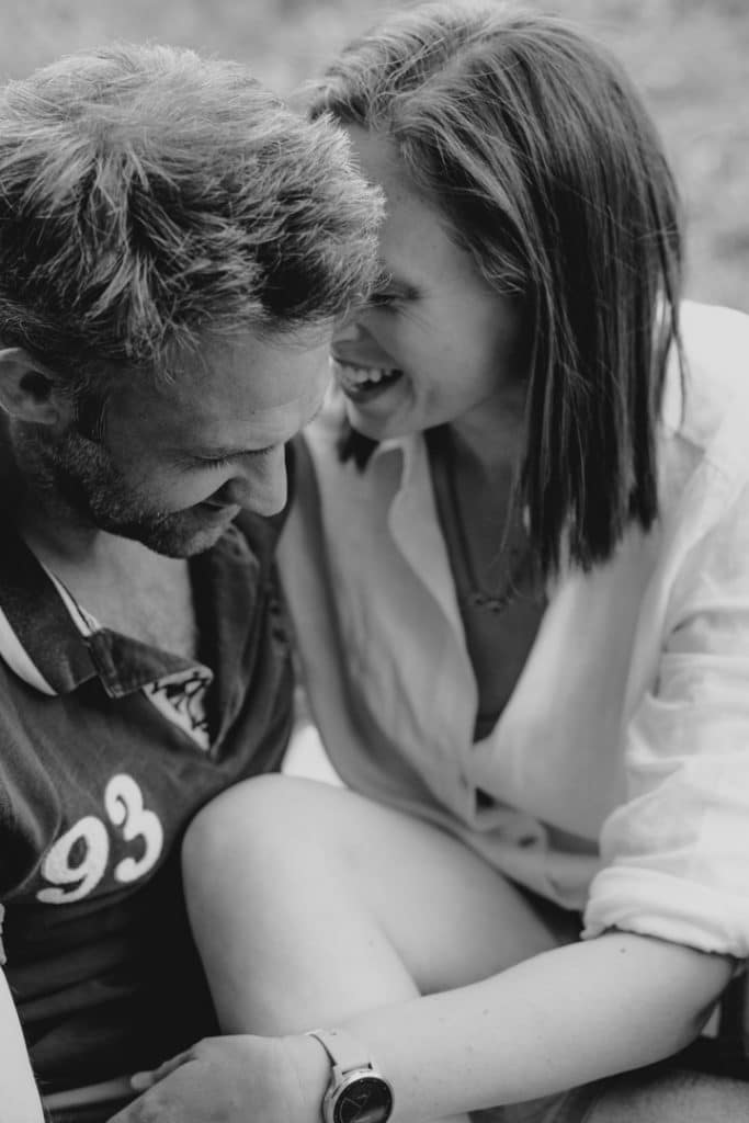 Mum and dad are sitting close to each other and smiling to each other. Natural lifestyle photoshoot in Hampshire. Ewa Jones Photography