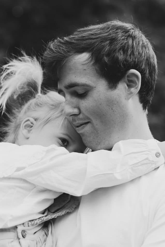 Dad is cuddling his girl in his arms. Lifestyle photoshoot in Hampshire. Ewa Jones Photography