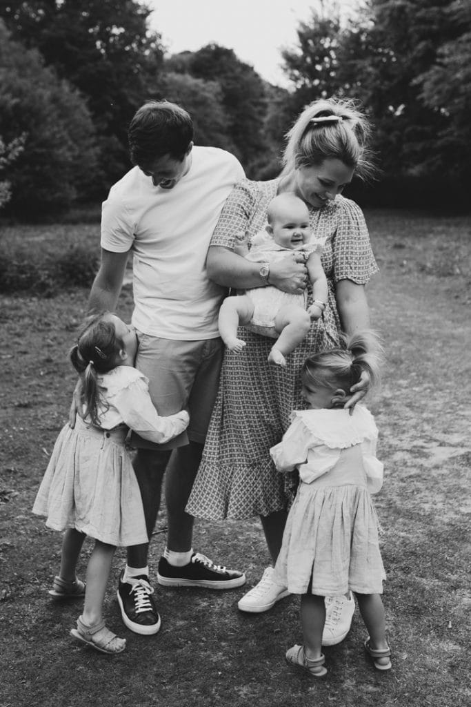 Lifestyle family photoshoot in Hampshire. Parents are cuddling their three daughters. Family photographer in Hampshire. Ewa Jones Photography