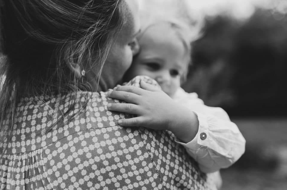 Lifestyle family photoshoot in Hampshire. Black and white image of mum holding her little girl in her arms. Hampshire photographer. Ewa Jones Photography. Benefits of an outdoor family photoshoot