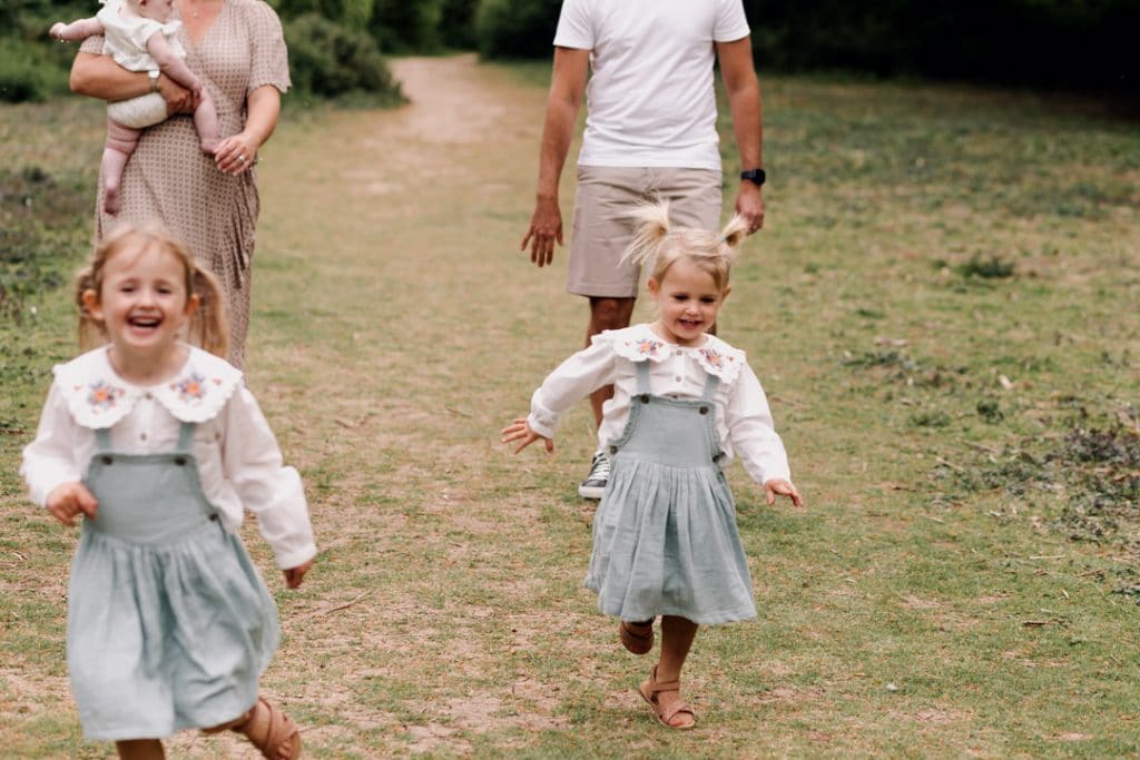 two girls are running towards the photographer. Family photo shoot in Hampshire. Ewa Jones Photography