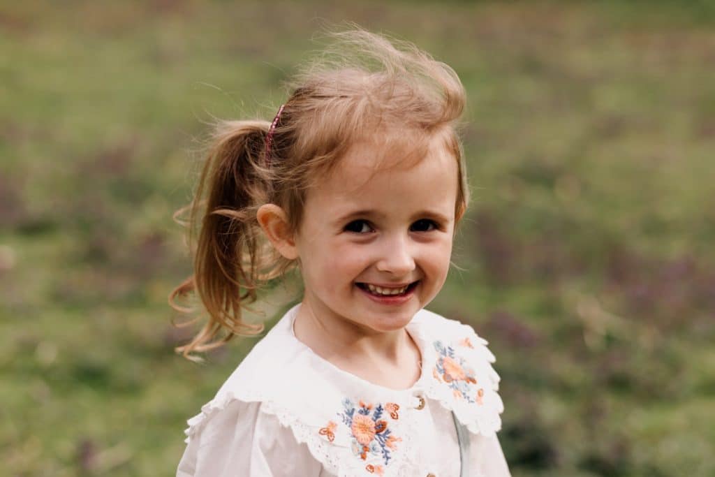 Little girl is smiling and looking at the camera. Family photo session in Basingstoke, Hampshire