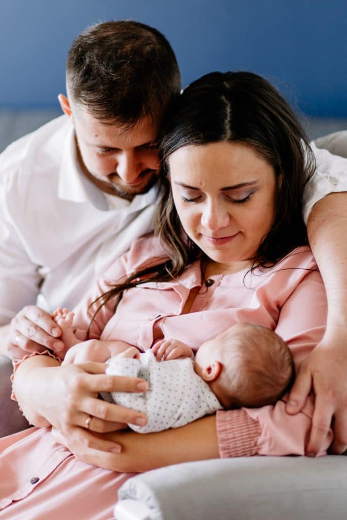 Mum and dad are cuddling and looking at newborn baby boy. Basingstoke photographer. Ewa Jones Photography