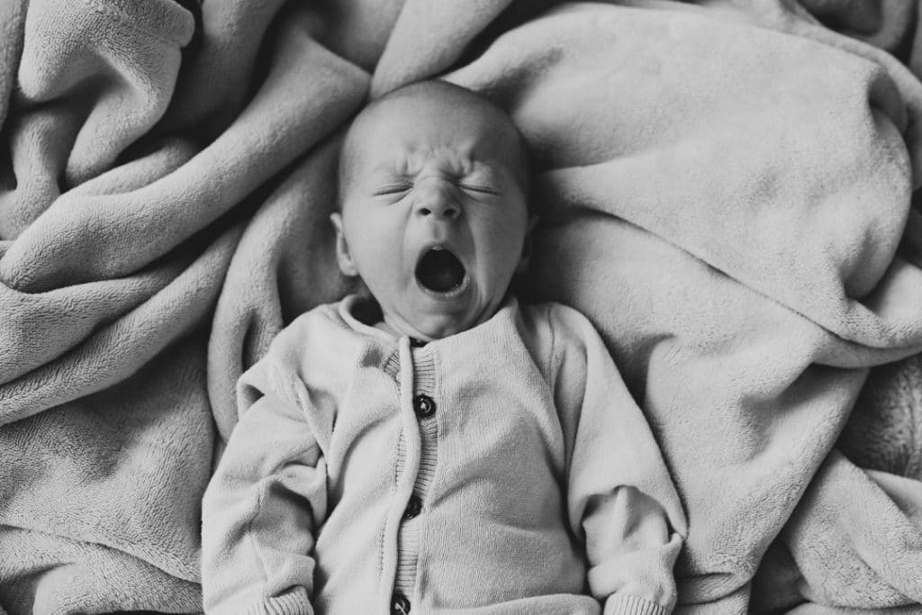 Newborn baby boy is yawning. newborn photoshoot in Basingstoke, Hampshire. Ewa Jones Photography