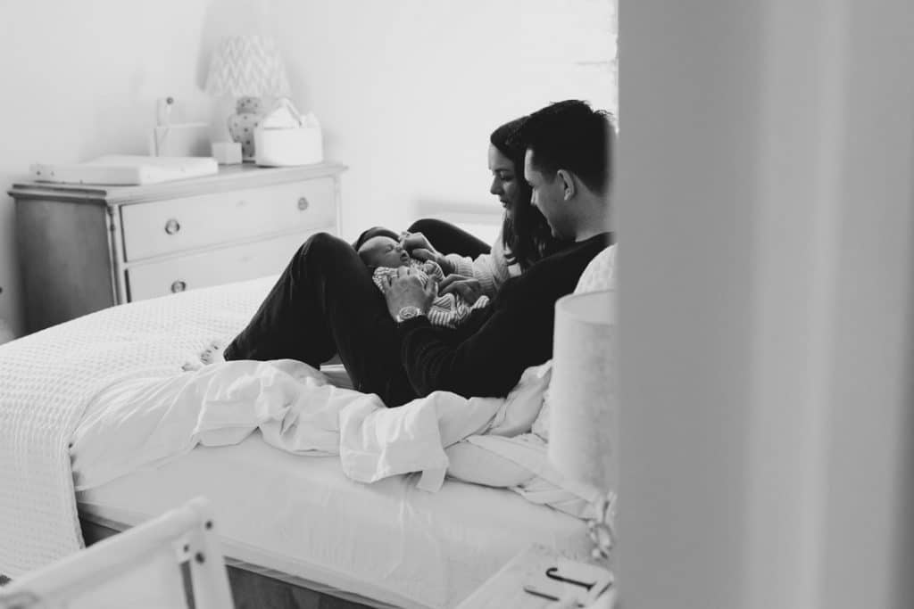 Black and white image of parents looking at their newborn baby boy. Newborn photo session in Hampshire. Ewa Jones Photography