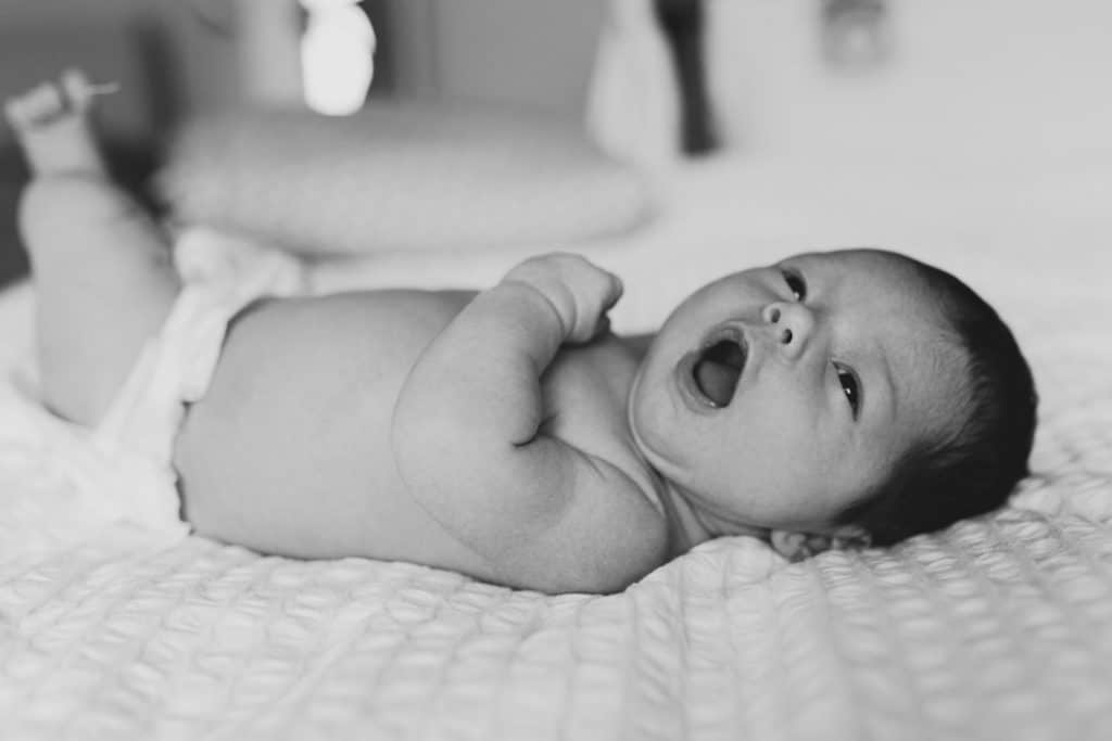 newborn baby is in the nappy and looking at parents. Newborn photo session in Farnham, Hampshire. Ewa Jones Photography
