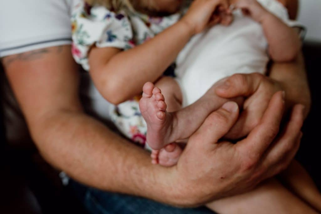 newborn is held in dads arms. Baby photoshoot in Hampshire. Ewa Jones Photography