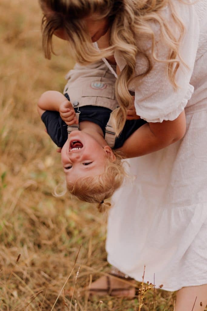mum is tickling her baby boy and he is laughing. family photo session in Hampshire. family fun. happiness. Ewa Jones Photography