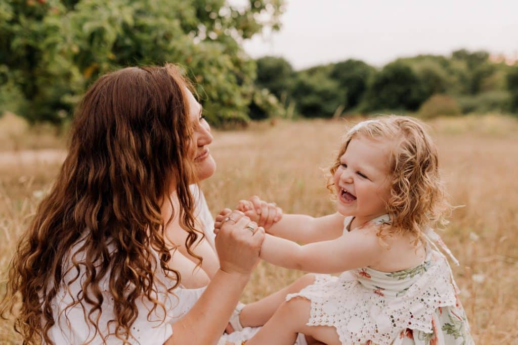 mum is smiling to her daughter and they are playing row row the boat. family photo session in Basingstoke. Basingstoke photographer. Happiness. family time. family photo session. Ewa Jones Photography