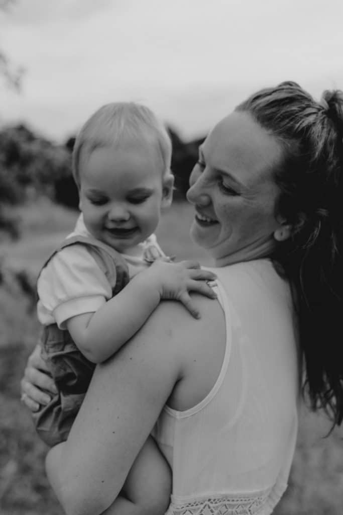 Mum is looking at her boy and smiling to him. boy is looking down and smiling too. natural lifestyle family photo session. Hampshire photographer. Basingstoke photography. Ewa Jones Photographer