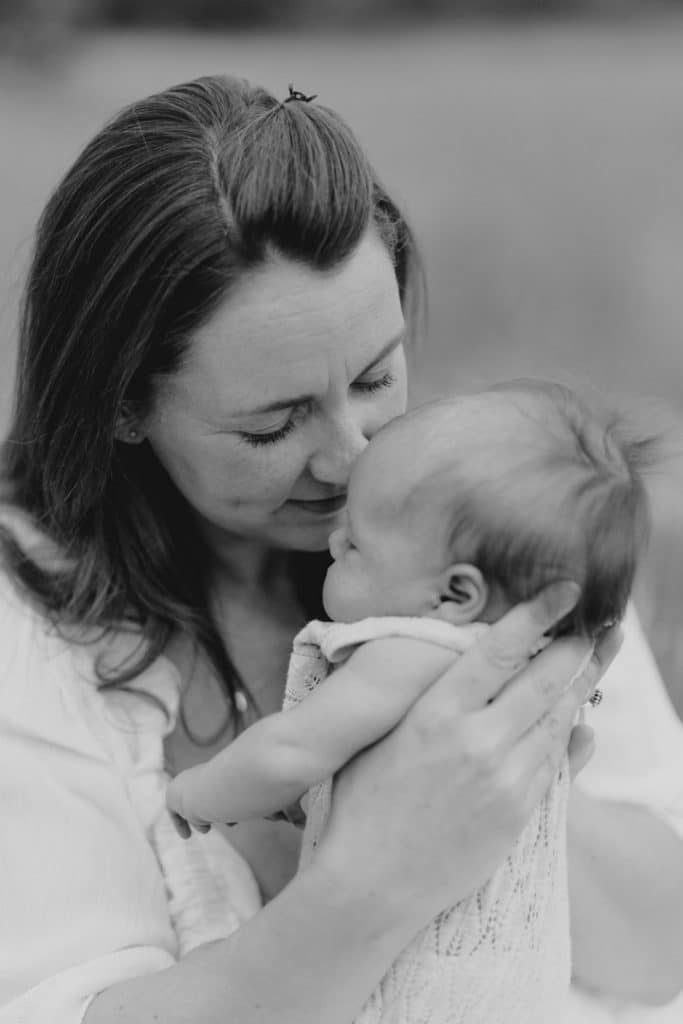 black and white image of mum cuddling close her baby girl. Newborn photo shoot outdoors. Newborn photographer. Hampshire photographer. Ewa Jones Photography