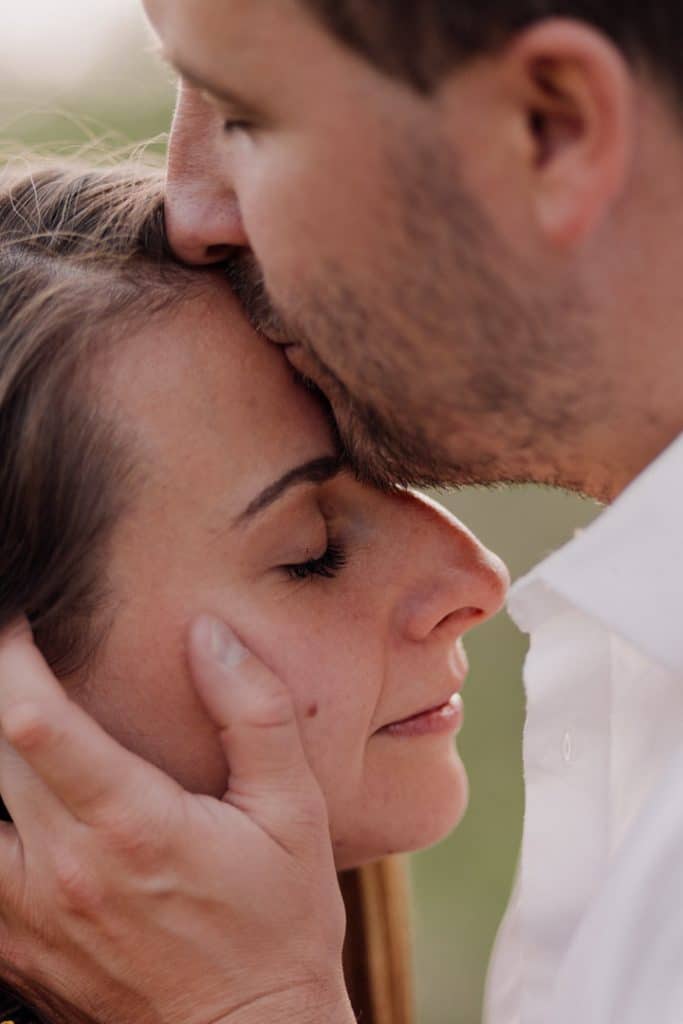 man is kissing woman in her forehead. lovely intimate couple photo session in hampshire. Basingstoke photographer. Ewa Jones Photography