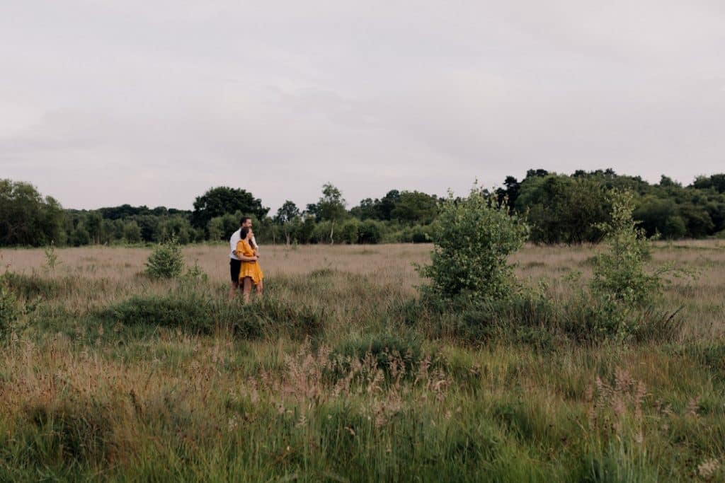couple is standing in the wild field and cuddling to each other. Couple and engagement photo session in Hampshire. Ewa Jones Photography