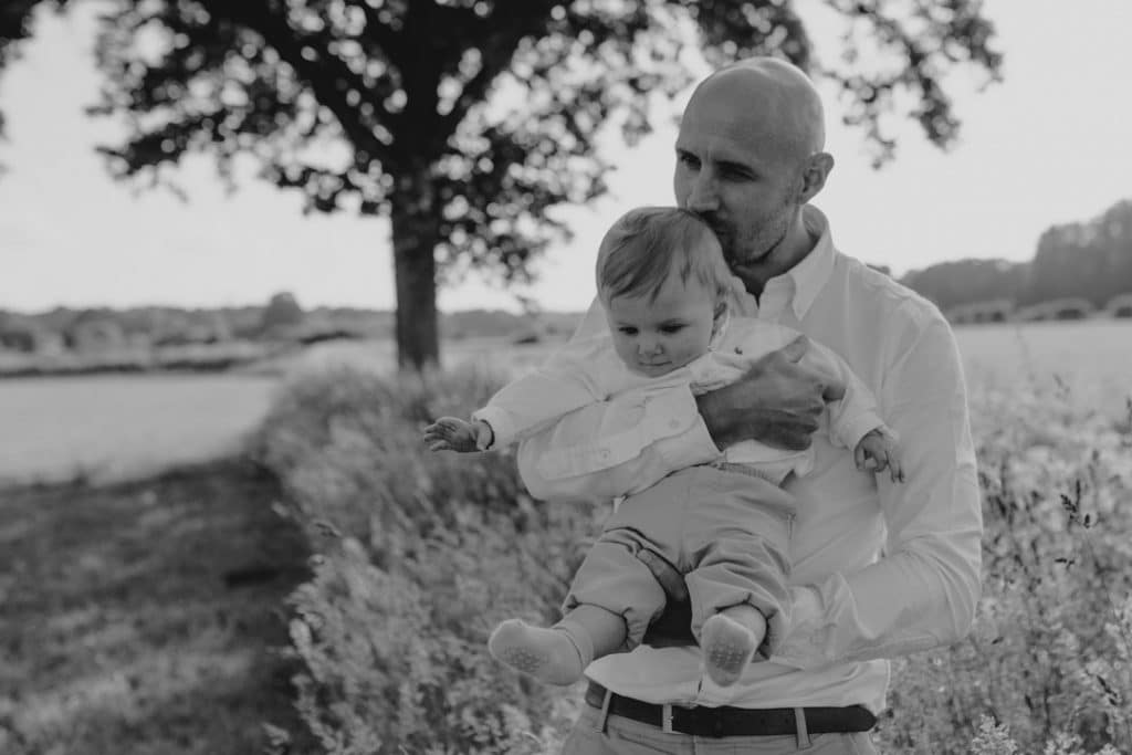 Family photo session in Hampshire countryside-12 dad is kissing his baby boy on his head. lovely candid family photo session in Hampshire. Hampshire photographer. Ewa Jones Photography