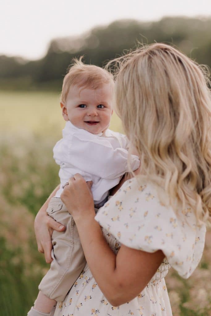 Family photo session in Hampshire countryside-2 Mum is holding her baby boy in her arms and boy is looking at his dad. Family photo session in Hampshire. Hampshire family photographer. Ewa Jones Photography