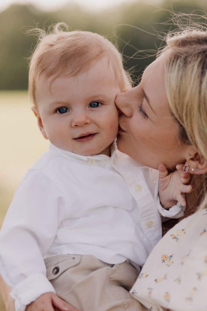 Family photo session in Hampshire countryside-3 Mum is kissing her baby boy in his cheek. Natural lifestyle family photo shoot in Hampshire. Basingstoke photographer. Ewa Jones Photography