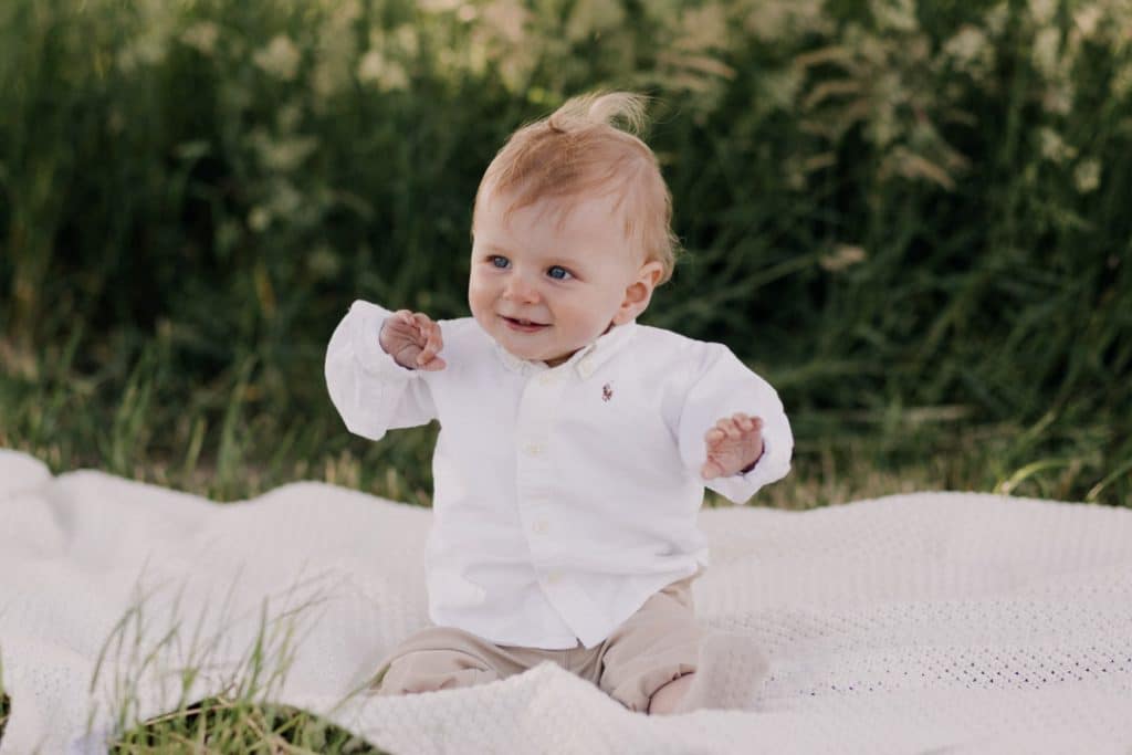 Family photo session in Hampshire countryside-7 little boy is sitting on the blanket and smiling. family photo session in Hampshire. Family photographer in Hampshire. Ewa Jones Photography
